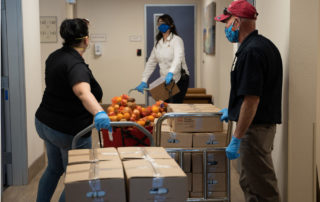 two hispanic females and one hispanic male working in the Golden Groceries at Senior Communities photo galleries